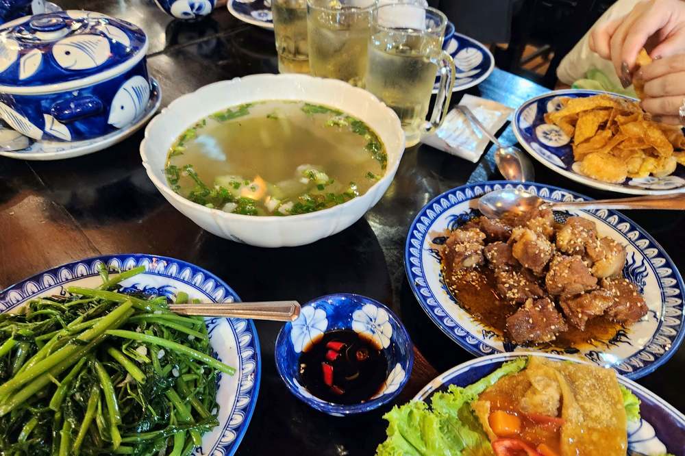 Group meal with soup, greens and local dishes in Hoi An