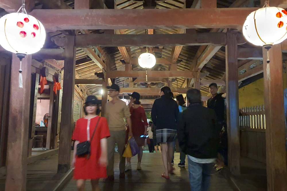 Visitors walking through the inside of the Japanese Covered Bridge