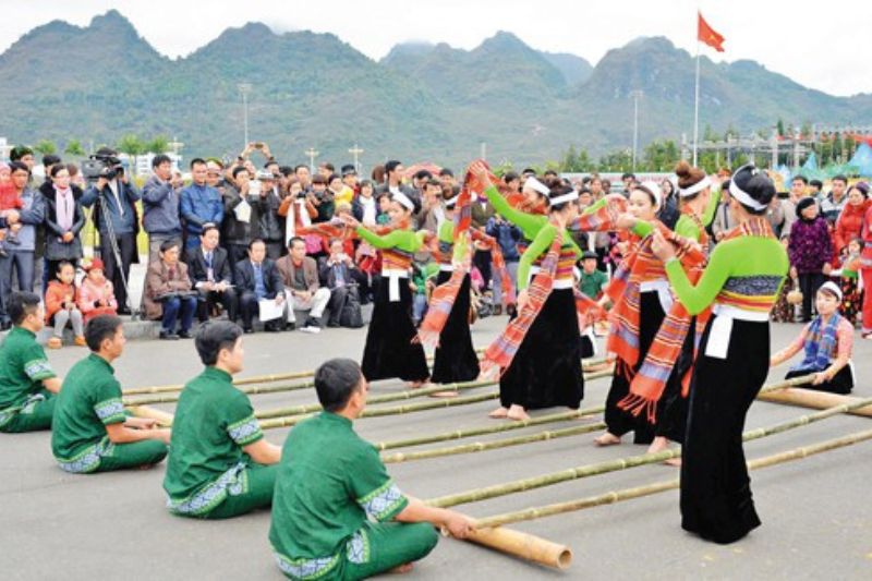 Vietnamese bamboo dance with performers stepping rhythmically between moving bamboo poles during festival