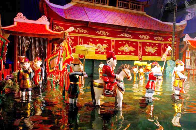 Vietnamese water puppetry show with puppets performing on water stage controlled by hidden puppeteers