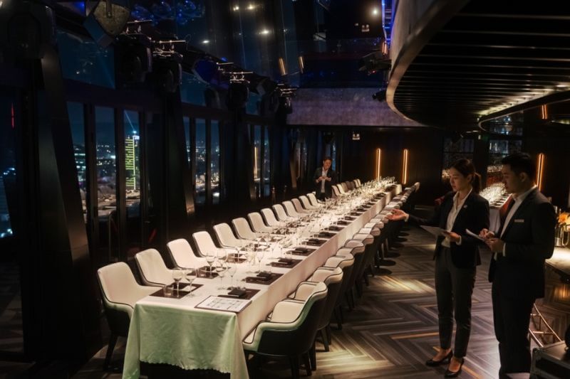 Dong DMC coordinator conducting site recce to verify private room layout and access route before group dinner