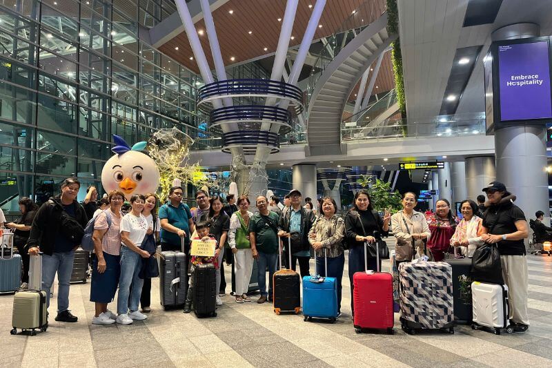 Dong DMC airport welcome team coordinating multi-coach arrivals with partner-branded signage for a 45-pax group