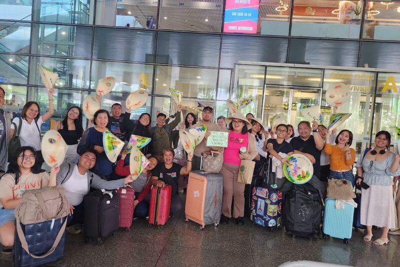 Dong DMC airport welcome team in Ho Chi Minh City with partner-branded signage and timestamped group pickup list