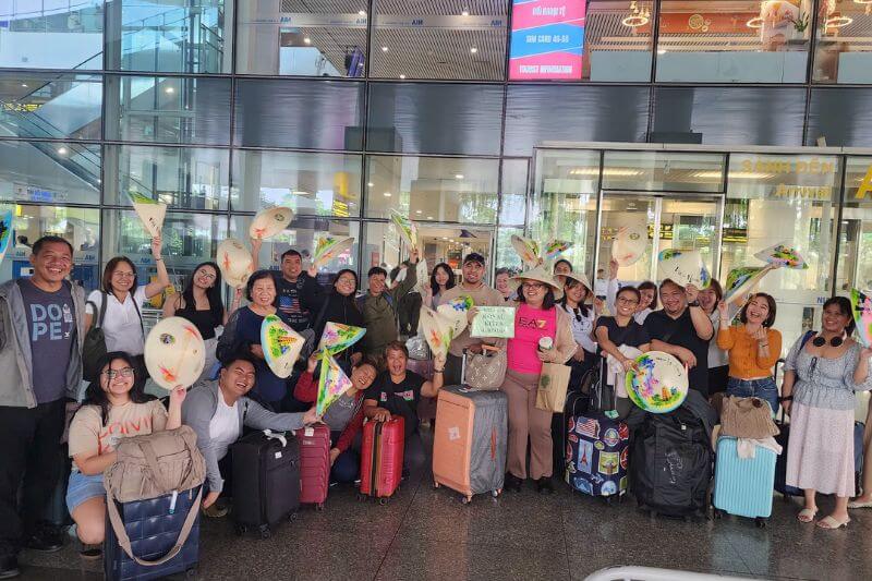 Partner-branded airport welcome signage with numbered coach bay assignments and team radios for a 40-pax series departure arrival flow