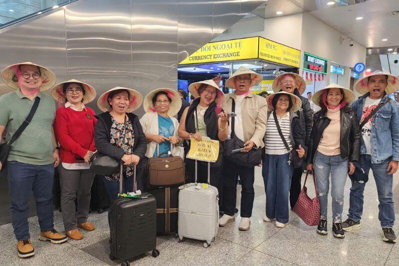 Airport welcome team with partner-branded signage and split-flow roles for group arrival handling and guide continuity control