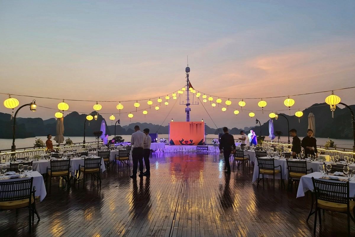 Gala dinner set up on a cruise sundeck in Halong Bay at dusk