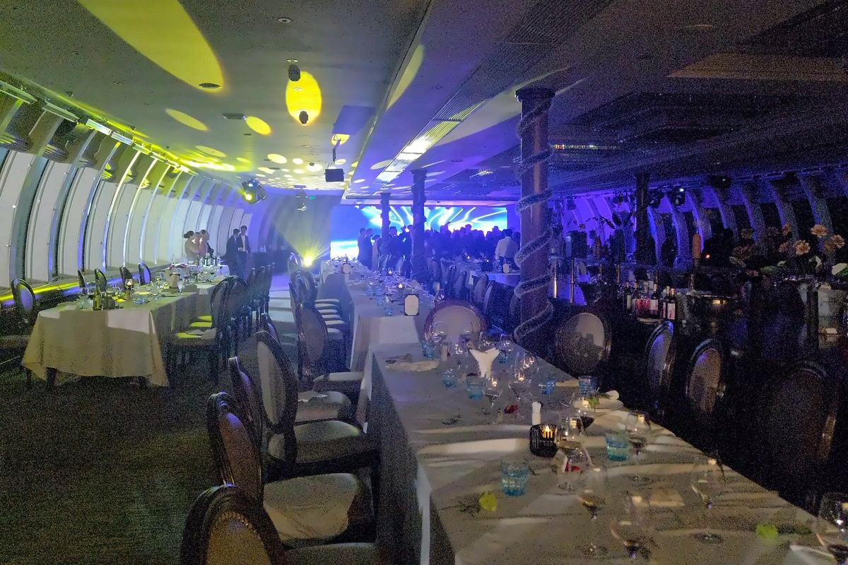 Long dinner tables in the dining hall of a Halong Bay cruise