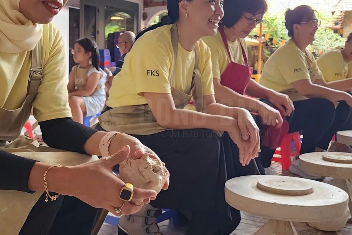 Hands shaping clay on a pottery wheel during a group workshop