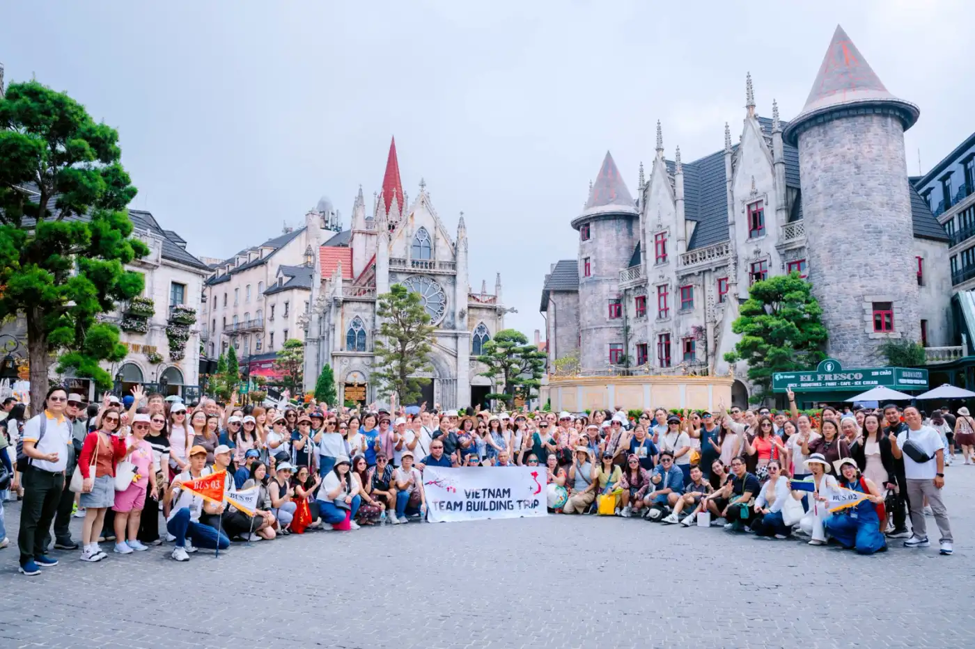 Corporate team-building group from the Philippines with bus flags at Ba Na Hills, Da Nang